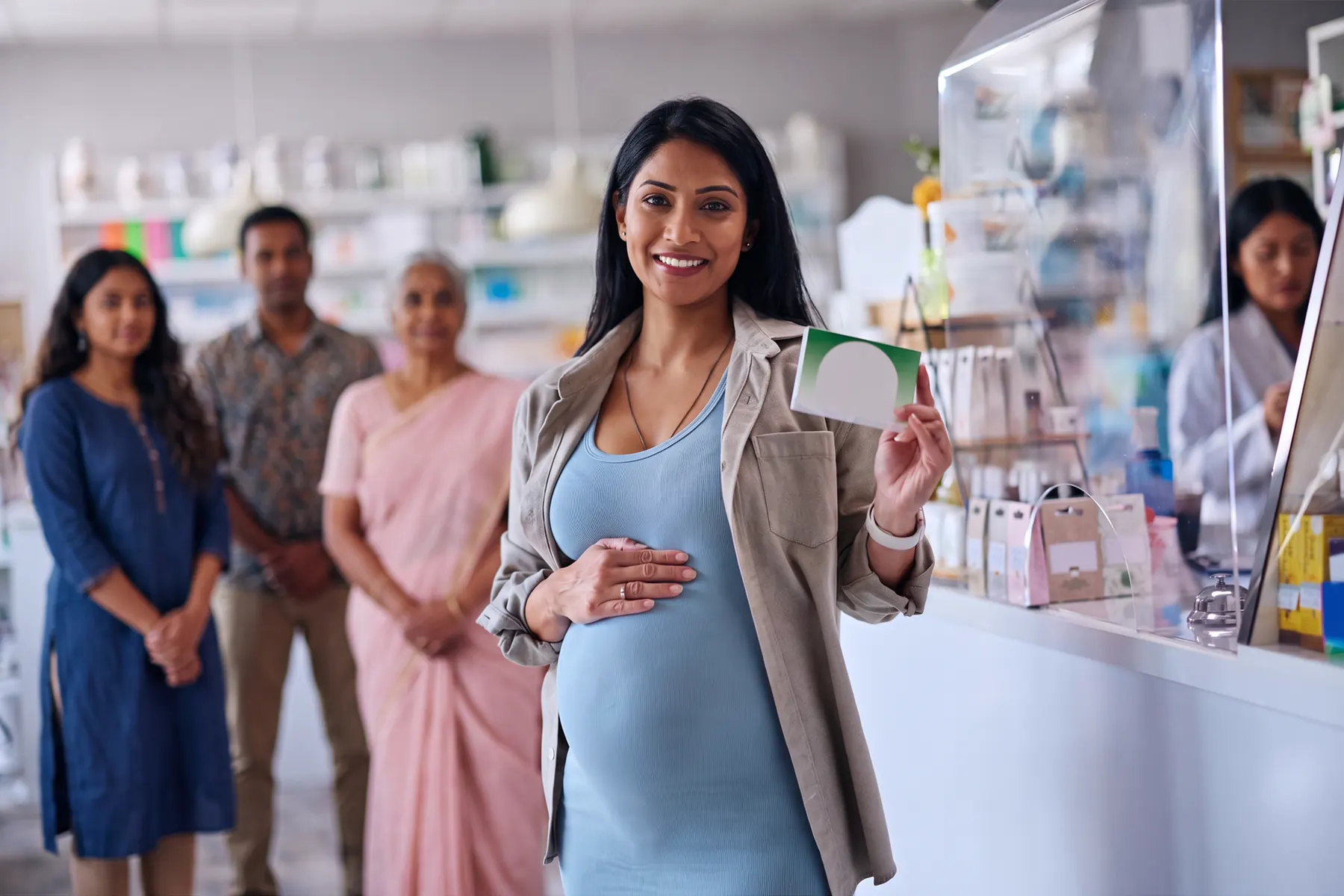 Pregnant woman holding medication in a pharmacy